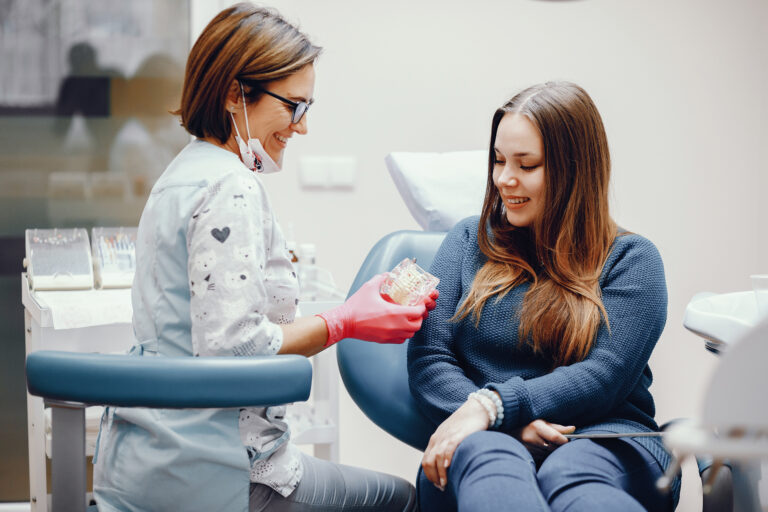 Girl talking to the dendist. Beautiful lady in the dentist's office. Woman in a uniform